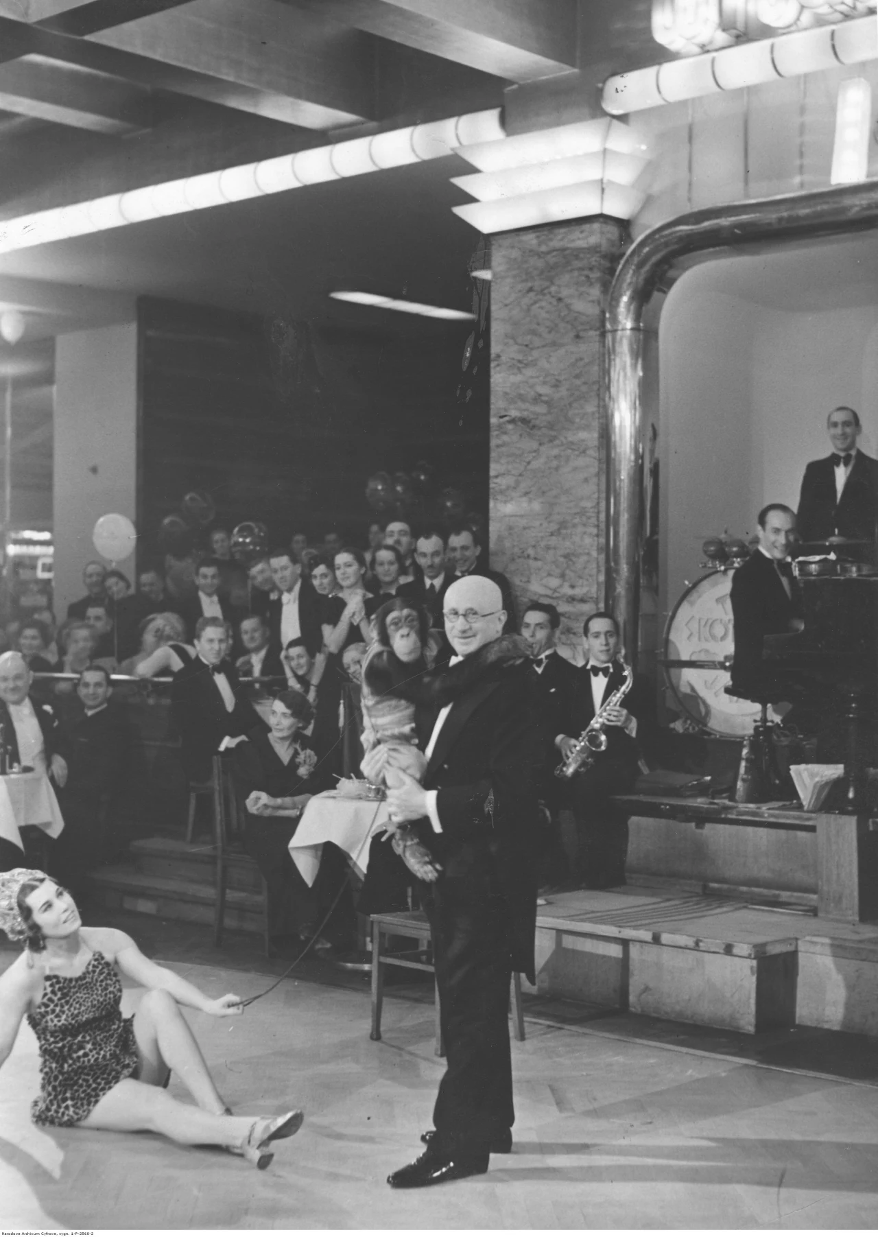 Kierownik i współwłaściciel lokalu "Adria" Franciszek Moszkowicz z szympansem. Na drugim planie widoczni uczestnicy balu