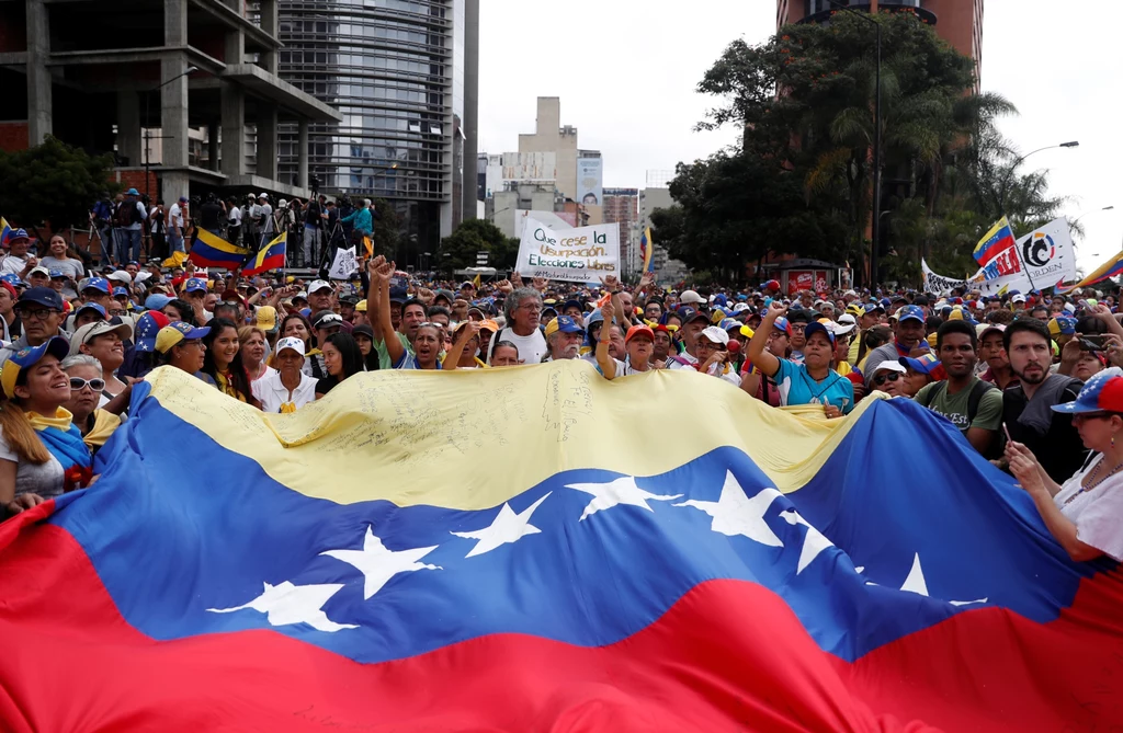 Demonstranci wyszli w środę (23 stycznia) na ulice wielu wenezuelskich miast, żądając ustąpienia socjalistycznego prezydenta Nicolasa Maduro i jego rządu. W czasie masowych protestów lider wenezuelskiej opozycji i przewodniczący parlamentu Juan Guaido ogłosił się tymczasowym prezydentem kraju. Uczynił to przed tłumem kilku tysięcy wiwatujących na jego cześć manifestantów w stolicy kraju - Caracas. Demonstranci wyszli w środę (23 stycznia) na ulice wielu wenezuelskich miast, żądając ustąpienia socjalistycznego prezydenta Nicolasa Maduro i jego rządu. W czasie masowych protestów lider wenezuelskiej opozycji i przewodniczący parlamentu Juan Guaido ogłosił się tymczasowym prezydentem kraju. Uczynił to przed tłumem kilku tysięcy wiwatujących na jego cześć manifestantów w stolicy kraju - Caracas.