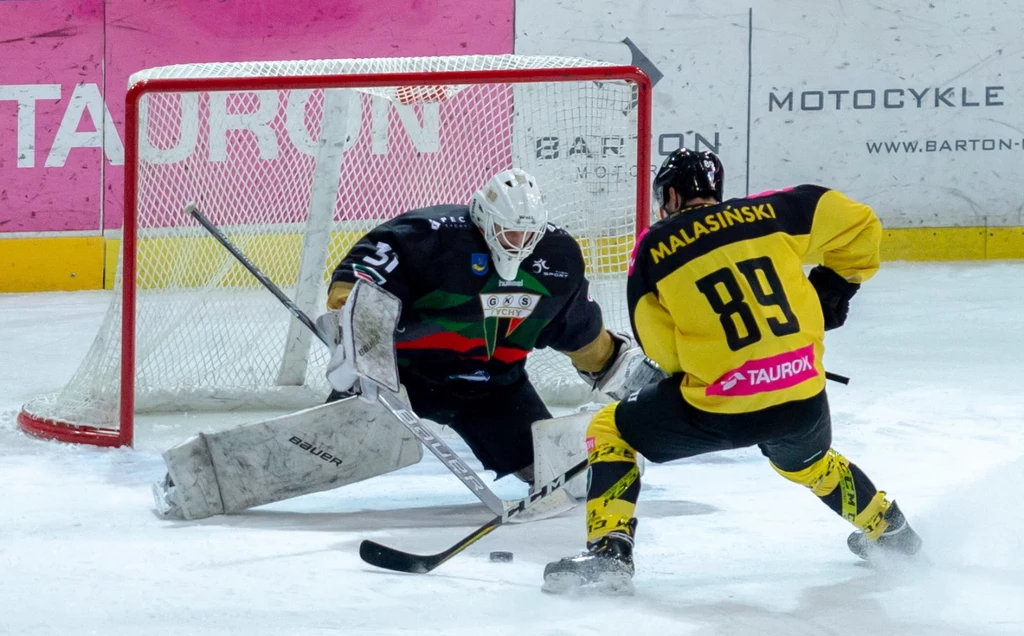 Zawodnik Tauronu KH GKS Katowice wykonujący rzut karny - Tomasz Malasiński (P) i bramkarz John Murray (L) z GKS Tychy