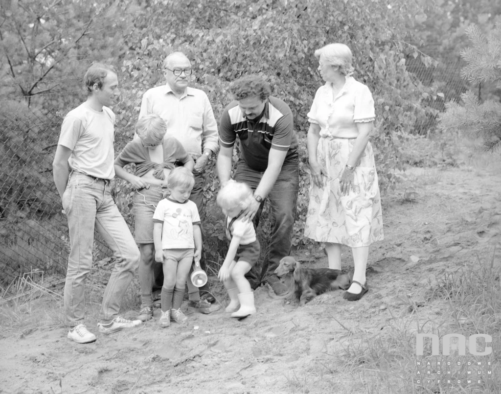 Rodzice z dziećmi na działce bawią się w poszukiwaczy skarbów/1988rok/NAC