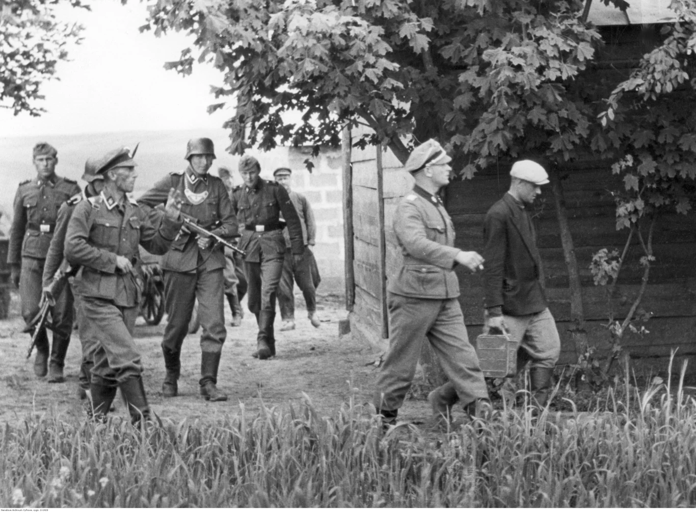 Żołnierze i żandarmi niemieccy podczas przeszukiwania wiejskich zabudowań w czasie wojny (zdjęcie ilustracyjne) Żołnierze i żandarmi niemieccy podczas przeszukiwania wiejskich zabudowań w czasie wojny (zdjęcie ilustracyjne)