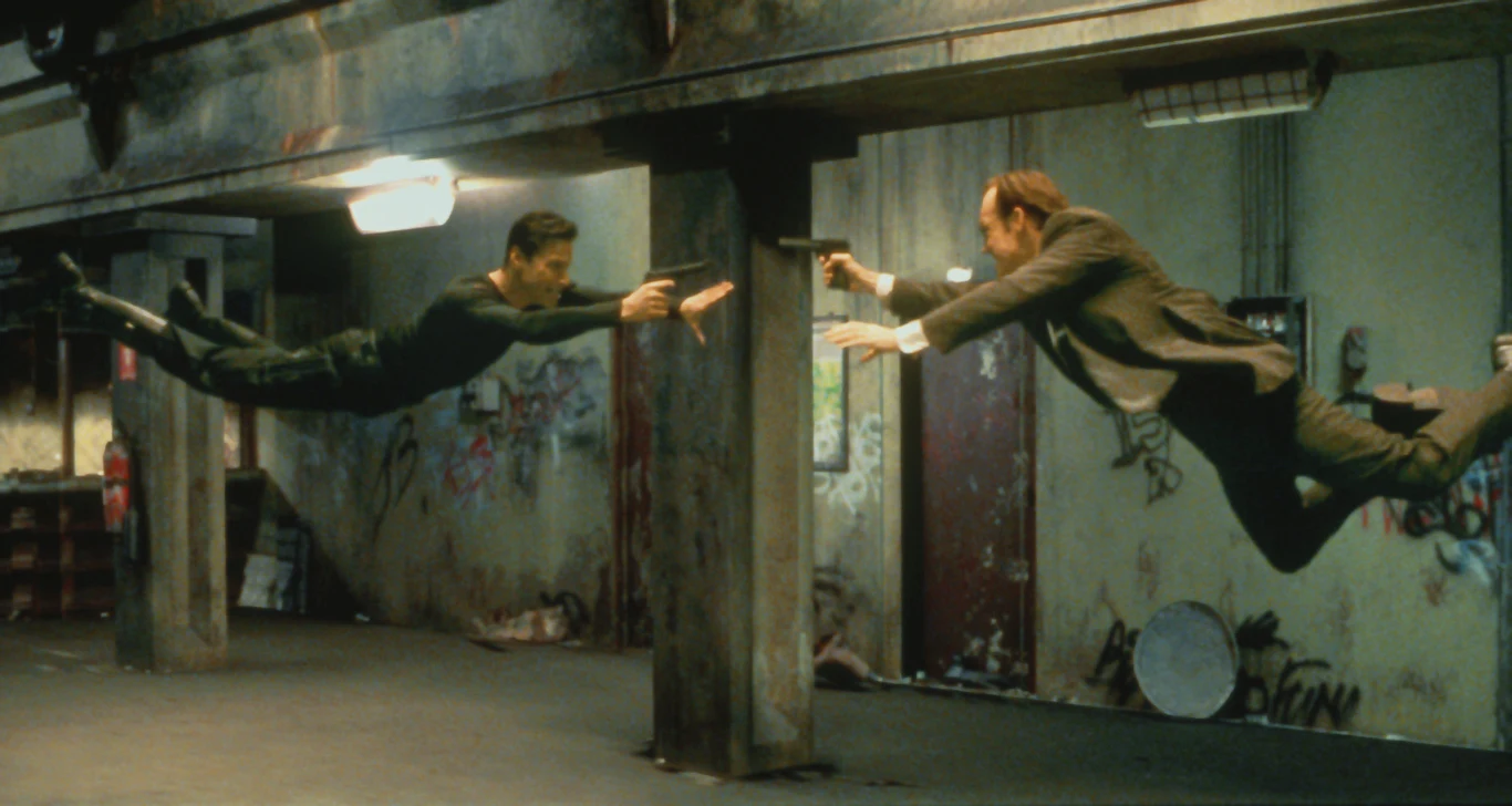 "Matrix" opowiadał historię programisty Thomasa Andersona (Keanu Reeves), który prowadzi drugie życie jako haker Neo. Czując, że ze światem jest coś nie tak, bohater trafia na trop Morfeusza (Laurence Fishbourne) - według przedstawicieli władz groźnego terrorysty. Ten kontaktuje się z Neo i wyjawia niewiarygodną prawdę - świat, który ich otacza, jest komputerową projekcją. Planetą rządzą maszyny, które hodują ludzi i traktują ich jako pożywienie. Morfeusz wierzy w przepowiednię, wedle której ludzi wyzwoli wybraniec - nim ma być właśnie Neo.
 
Na zdjęciu: Keanu Reeves i Hugo Weaving w filmie "Matrix"