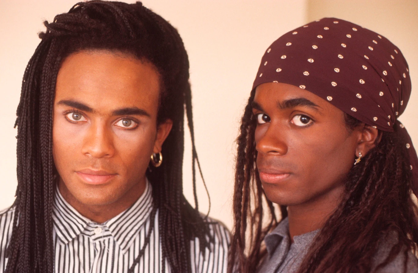 W skład Milli Vanilli wchodzili Rob Pilatus (z lewej) oraz Fabrice Morvan. Projekt wspierał również producent Frank Farian. Zespołowi początkowo szło fantastycznie: miał platynowy album "Girl You Know It's True" i hity z pierwszych miejsc list przebojów - "Girl I'm Gonna Miss You", "Baby Don't Forget My Number", "Blame It On The Rain". Świat stał przed nimi otworem. Wkrótce wyszło jednak na jaw, że Rob i Fab to oszuści, którzy tylko udają piosenkarzy. Młodzi gwiazdorzy byli jedynie twarzami projektu, a w studiu zastępowali ich inni wokaliści: Charles Shaw i Brad Howell. Na koncertach śpiewali z playbacku, co wykryto w 1989 roku podczas występu w Connecticut. Wówczas zacięła się taśma z przebojem "Girl You Know It's True", a zestresowani członkowie Milli Vanilli uciekli ze sceny. W 1990 roku zespół otrzymał nagrodę Grammy za album "Girl You Know It's True" (amerykańskie wydanie nieco zmienione w stosunku do europejskiej płyty nosiło tytuł "All Or Nothing"), jednak na skutek krytyki w mediach po czterech dniach decyzja została cofnięta. Rob Pilatus po skandalu przeszedł załamanie nerwowe, które doprowadziło go ostatecznie do śmierci. Wokalista 2 kwietnia 1998 roku zmarł w wieku 33 lat po przedawkowaniu narkotyków i alkoholu. 