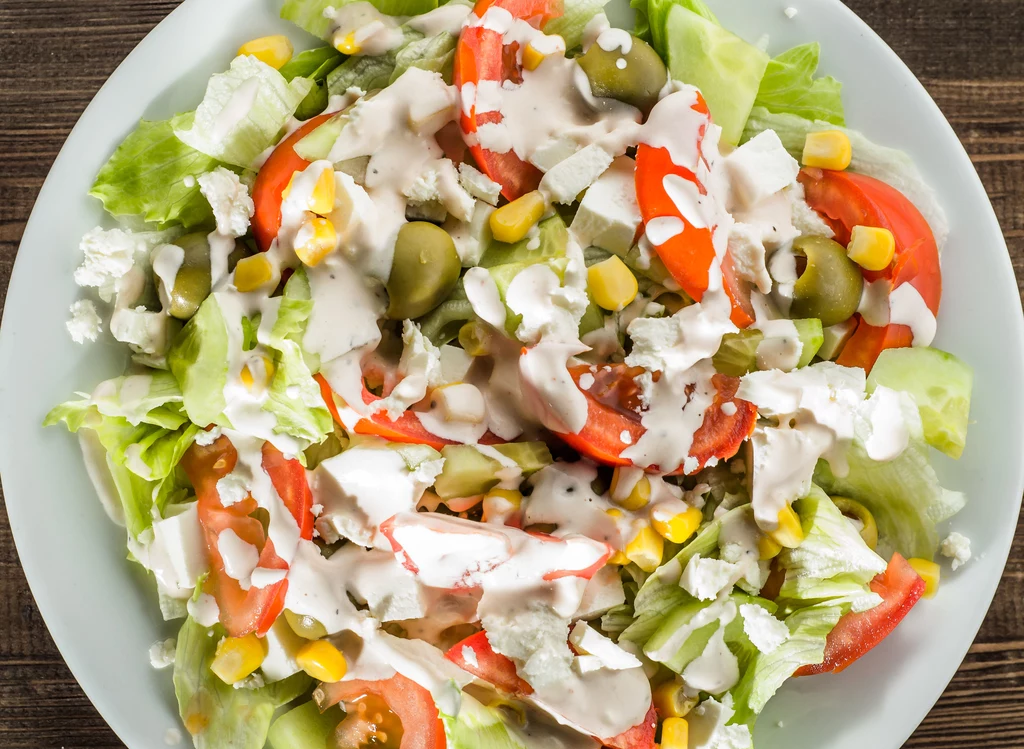 Sałatka to posiłek dietetyczny i niskokaloryczny – pod warunkiem, że nie oblejesz jej tłustym dressingiem. Świeża sałata ma zaledwie 15 kcal w 100 gramach, ze śmietaną – 40, z oliwą – 50, a z sosem czosnkowym aż 194 kcal! Należy też dodać, że gotowe sosy sałatkowe są na ogół niezdrowe – zawierają konserwanty, zagęszczacze i stabilizatory, które mogą powodować alergie oraz wzdęcia. Dressing sałatkowy najlepiej przygotować samodzielnie, na bazie niewielkiej ilości dobrej jakościowo oliwy lub jogurtu naturalnego. Sałatka to posiłek dietetyczny i niskokaloryczny – pod warunkiem, że nie oblejesz jej tłustym dressingiem. Świeża sałata ma zaledwie 15 kcal w 100 gramach, ze śmietaną – 40, z oliwą – 50, a z sosem czosnkowym aż 194 kcal! Należy też dodać, że gotowe sosy sałatkowe są na ogół niezdrowe – zawierają konserwanty, zagęszczacze i stabilizatory, które mogą powodować alergie oraz wzdęcia. Dressing sałatkowy najlepiej przygotować samodzielnie, na bazie niewielkiej ilości dobrej jakościowo oliwy lub jogurtu naturalnego.