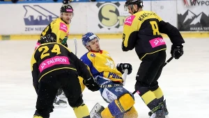 Hokeista TatrySki Podhala Nowy Targ Kacper Guzik (C) oraz Martin Cakajik (L) i Patryk Krężołek (P) z Tauronu KH GKS Katowice 