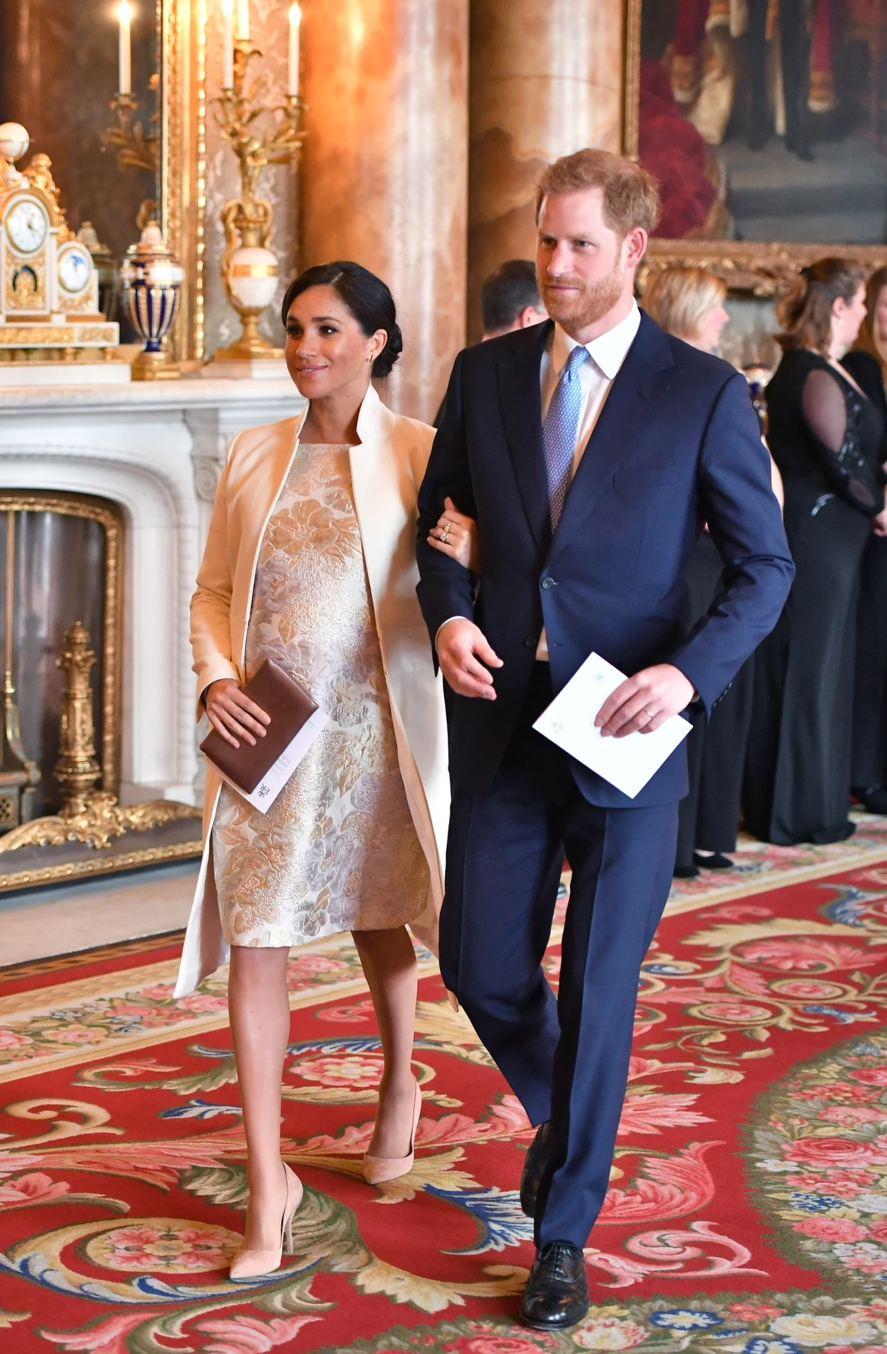 Połyskująca suknia i biały płaszcz od Amandy Wakeley to wybór Meghan na przyjęcie z okazji 50. rocznicy inwestytury księcia Karola na księcia Walii.