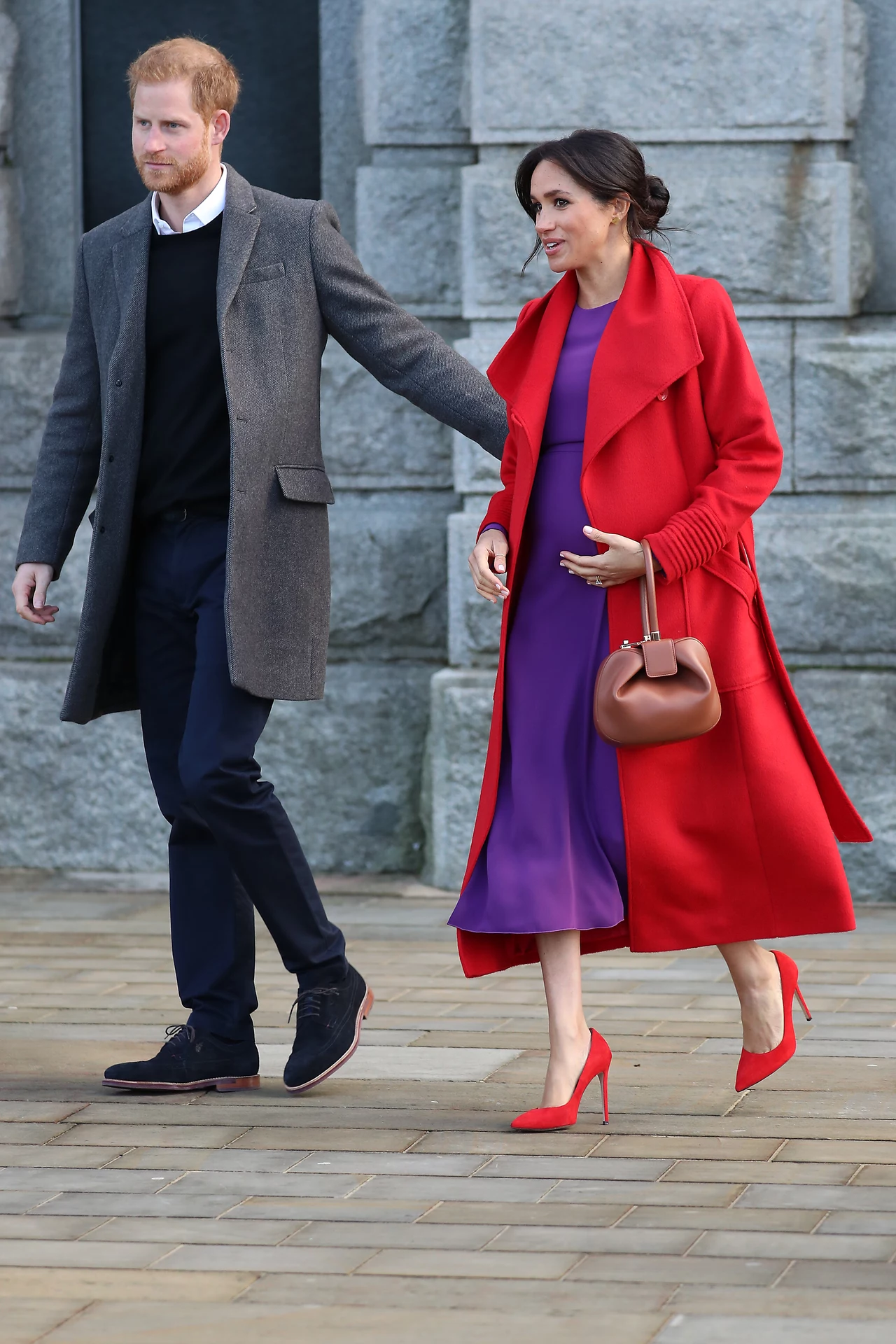 W Birkenhead Meghan pojwiła się w czerwonym płaszczu Sentaler i fioletowej sukience Aritzia. 