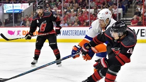 Anders Lee #27 z New York Islanders walczy z Sebastianem Aho #20 z Carolina Hurricanes