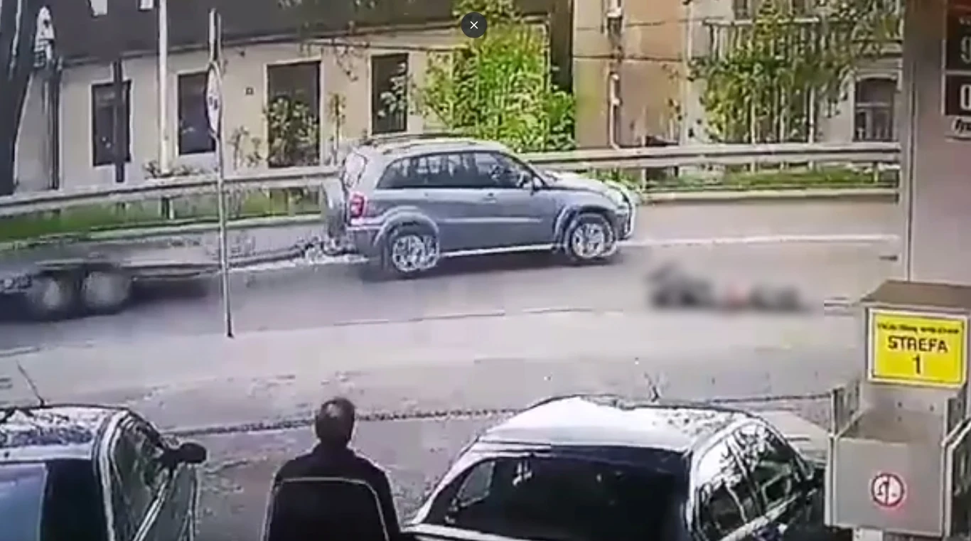 Mężczyzna tankujący auto przygląda się leżącemu, a kierujący suv-em... go omija!