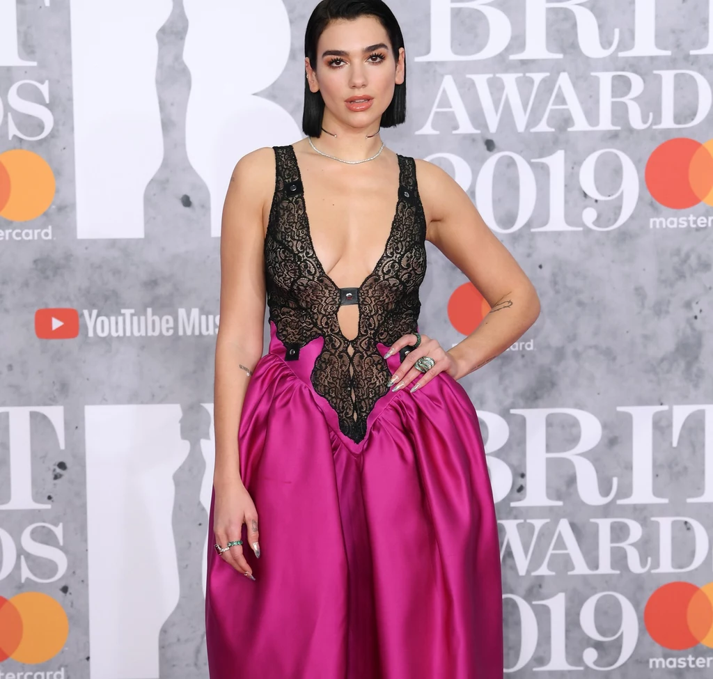 Dua Lipa na gali rozdania nagród Brit Awards pojawiła się w odważnej kreacji z koronkową, mocno wydekoltowaną górą i kontrastowym dołem w kolorze ostrego, fioletowego różu