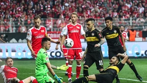 Łukasz Gikiewicz broni uderzenie zawodnika ze Stuttgartu
