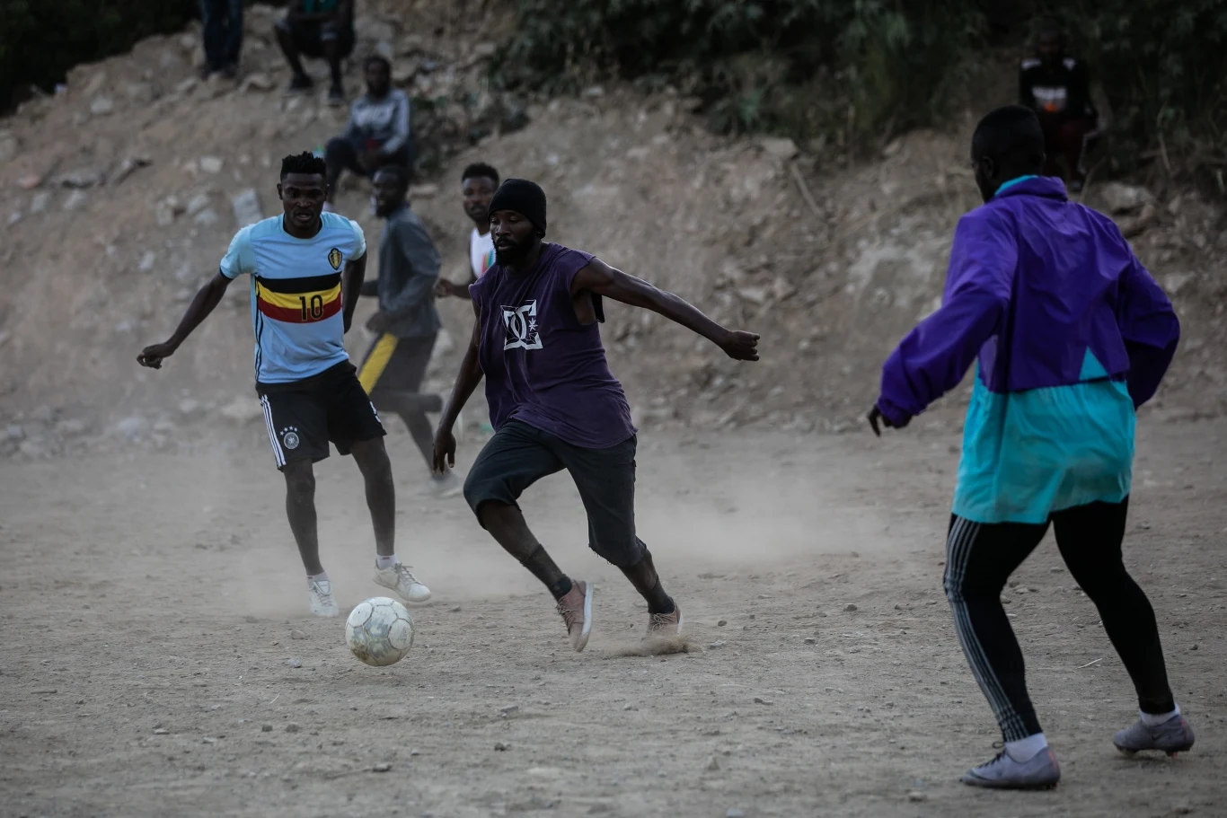 Grupa uchodźców podczas gry w piłkę nożną