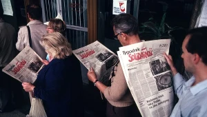 Ludzie w kolejce czytający pierwszy numer "Tygodnika Solidarność"