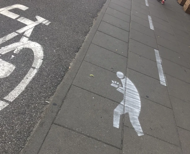 Niektórzy twierdzą, że znak informujący o tym, iż jest to pas dla wpatrzonych w telefon wygląda jakby miał być to pas dla kieszonkowców uciekających z łupem Niektórzy twierdzą, że znak informujący o tym, iż jest to pas dla wpatrzonych w telefon wygląda jakby miał być to pas dla kieszonkowców uciekających z łupem