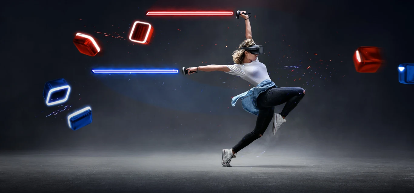 Oculus Quest, dwa kontrolery pełniące rolę mieczy świetlnych i gra "Beat Saber" Oculus Quest, dwa kontrolery pełniące rolę mieczy świetlnych i gra "Beat Saber"