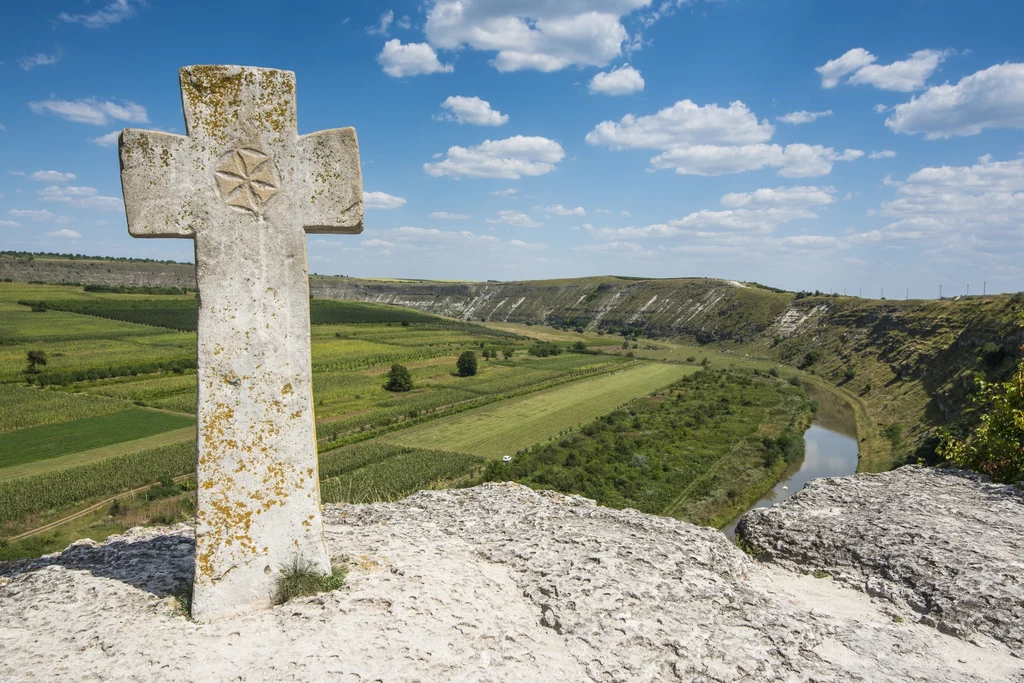 Stary, kamienny krzyż w Orheiul Vechi na tle pięknego krajobrazu jest jednym z najbardziej rozpoznawalnych obrazków z Mołdawii. Znajdziecie go na wielu widokówkach