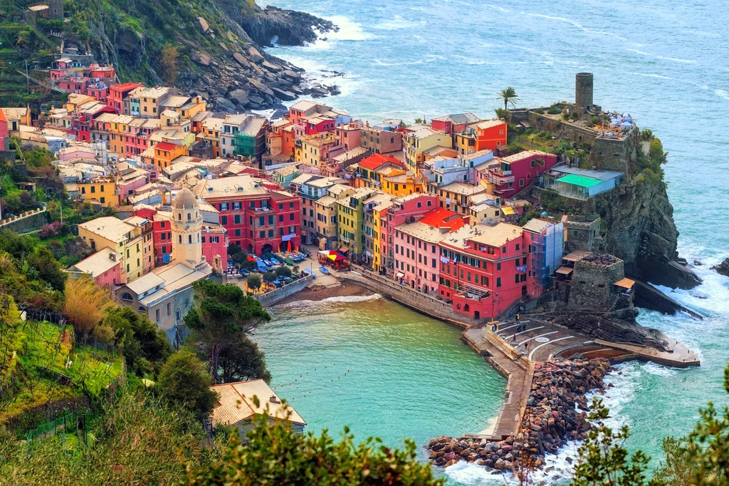 Vernazza - kameralna plaża, skały łączące się z Morzem Liguryjskim. Przez wielu uznawana za najładniejsze z miast Cinque Terre, mimo że wskutek powodzi w 2011 roku ucierpiała najbardziej. Pastelowe kamienice na wzgórzach są dopełnieniem uroku tego miejsca. Vernazza - kameralna plaża, skały łączące się z Morzem Liguryjskim. Przez wielu uznawana za najładniejsze z miast Cinque Terre, mimo że wskutek powodzi w 2011 roku ucierpiała najbardziej. Pastelowe kamienice na wzgórzach są dopełnieniem uroku tego miejsca.