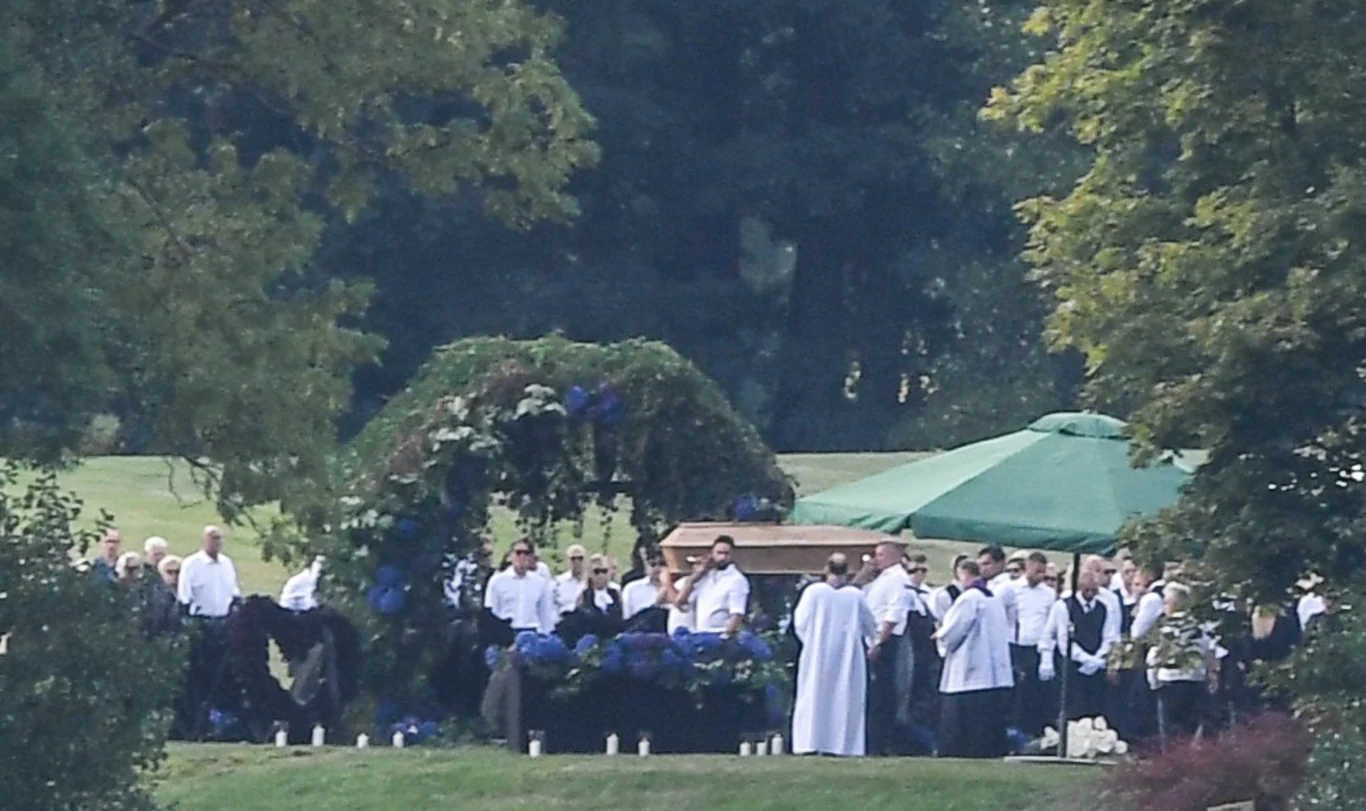 Według dziennika "Fakt" trumna ze szczątkami Woźniaka-Staraka została opuszczona do "specjalnie wykopanego dołu tuż przy łuku utkanym z bluszczu i fioletowych hortensji".