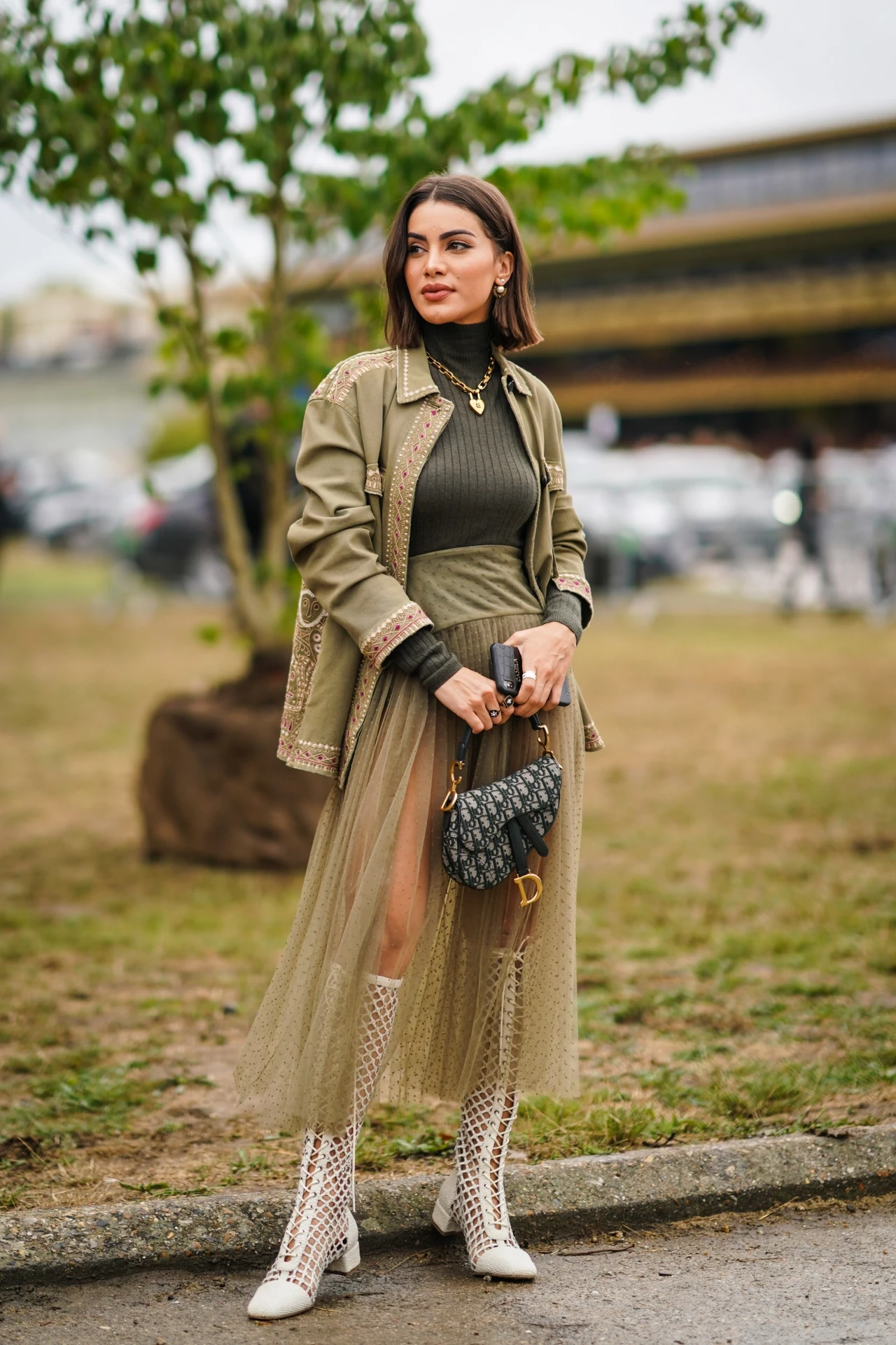Blogerka Camila Coelho założyła wełniany zielony golf, zwiewną spódnicę, kurtkę w kolorze khaki. Look uzupełniają ażurowe botki i torebka-siodło od Diora Blogerka Camila Coelho założyła wełniany zielony golf, zwiewną spódnicę, kurtkę w kolorze khaki. Look uzupełniają ażurowe botki i torebka-siodło od Diora