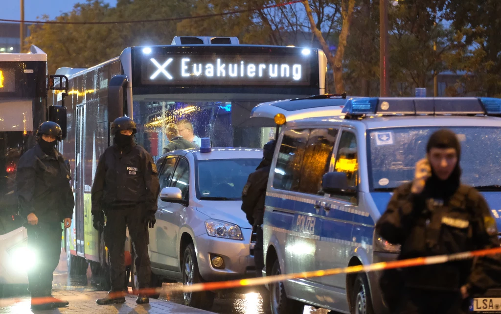 Widzimy więc dokładnie, jak napastnik stara się otworzyć drzwi synagogi. Te są jednak zamknięte, więc mężczyzna strzela do przypadkowej kobiety na ulicy. Po krótkiej walce z drzwiami wraca do atua i jedzie do baru z kebabem. Zacina mu się broń, lecz po krótkiej chwili strzela do osoby w środku. Widzimy więc dokładnie, jak napastnik stara się otworzyć drzwi synagogi. Te są jednak zamknięte, więc mężczyzna strzela do przypadkowej kobiety na ulicy. Po krótkiej walce z drzwiami wraca do atua i jedzie do baru z kebabem. Zacina mu się broń, lecz po krótkiej chwili strzela do osoby w środku.