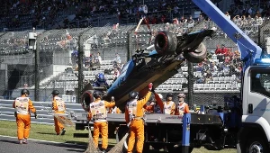 Ekipa porządkowa ściąga rozbity bolid Roberta Kubicy w kwalifikacjach do GP Japonii