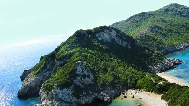 Natomiast Porto Timoni to dwie, sąsiadujące ze sobą plaże nad malowniczymi zatokami. Wrażenie robi także długa na trzy kilometry piaszczysta plaża Agios Georgios, położona w sąsiedztwie urokliwych lasów. Źródło: Rewia