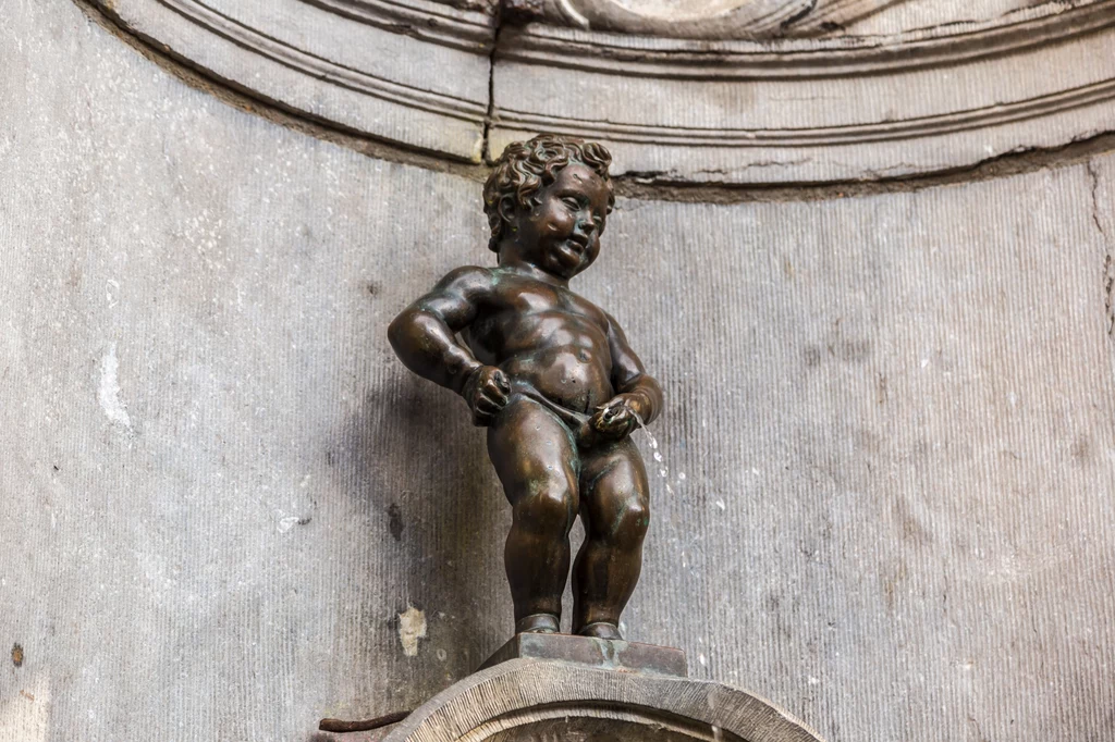 Siusiający chłopiec nazywany też Małym Julianem. Zanim stanęła wyrzeźbiona w 1619 r. figurka z brązu, wcześniejsza (kamienna) wersja, stała tu od połowy XIV w. Kto i dlaczego wpadł na pomysł tej symbolicznej postaci, tego nigdy nie dowiedziono. Jedna z wersji mówi, że pewien chłopiec ocalił miasto od zniszczenia, gasząc „bardzo swojskim sposobem” rozpalony lont bomby. Według innego podania figurka powstała dla upamiętnienia zaginionego w czasie jednej z bitew małego synka znanego mieszczanina, którego szczęśliwie odnaleziono w takiej pozycji pod murami miasta. Źródło: Świat i Ludzie Siusiający chłopiec nazywany też Małym Julianem. Zanim stanęła wyrzeźbiona w 1619 r. figurka z brązu, wcześniejsza (kamienna) wersja, stała tu od połowy XIV w. Kto i dlaczego wpadł na pomysł tej symbolicznej postaci, tego nigdy nie dowiedziono. Jedna z wersji mówi, że pewien chłopiec ocalił miasto od zniszczenia, gasząc „bardzo swojskim sposobem” rozpalony lont bomby. Według innego podania figurka powstała dla upamiętnienia zaginionego w czasie jednej z bitew małego synka znanego mieszczanina, którego szczęśliwie odnaleziono w takiej pozycji pod murami miasta. Źródło: Świat i Ludzie