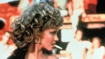 Olivia Newton-John w filmie wcielała się w rolę sympatycznej Sandy. W finale filmu przemieniła się w zadziorną dziewczynę m.in. za sprawą czarnego kostiumu. Aktorce partnerował John Travolta i razem wykonywali przebój "You're The One That I Want".