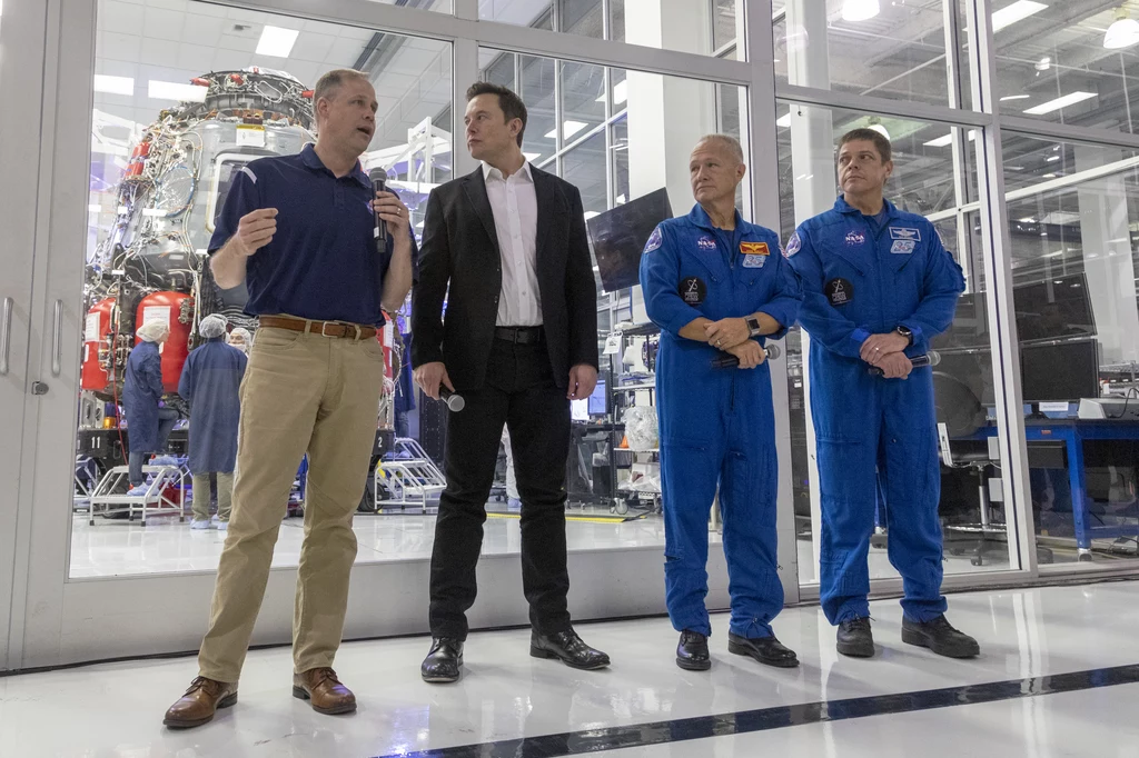 Administrator NASA (z lewej), Elon Musk i dwóch astronautów NASA - z tyłu widać kapsułę stworzoną przez SpaceX