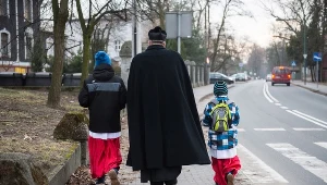 Ksiądz z ministrantami podczas wizyty duszpasterskiej, zdjęcie ilustracyjne