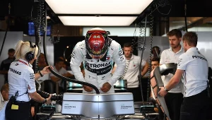 Lewis Hamilton zajmuje miejsce za kierownicą swojego bolidu w garażu Mercedesa