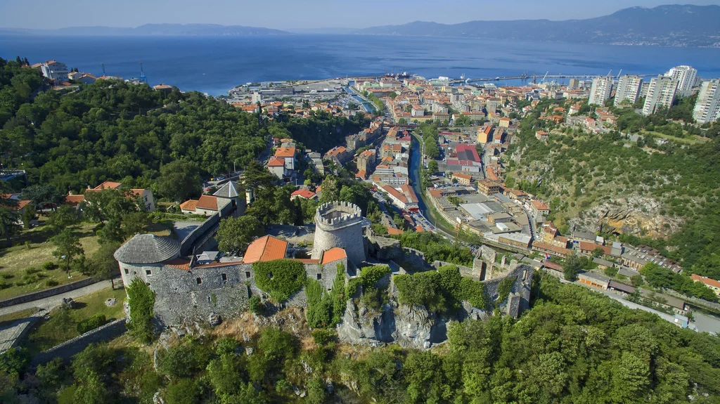Ze względu na fantastyczną panoramę zatoki Kvarner, do najpopularniejszych atrakcji turystycznych Rijeki należy górująca nad miastem twierdza na wzgórzu Trsat. Pierwsze fortyfikacje zbudowano tam jeszcze w starożytności, dziś zamek - odbudowany w XIX w. po trzęsieniu ziemi w 1750 r. - dostępny jest dla zwiedzających. Nieopodal znajduje się klasztor i kościół Matki Boskiej z Trsatu, będące ważnym celem pielgrzymek. Znajduje się tam wiele pięknych, cennych artefaktów, w tym gotycka figura Matki Boskiej z Trsatu. Fot. Ivo Biočina, Chorwacka Wspólnota Turystyczna Ze względu na fantastyczną panoramę zatoki Kvarner, do najpopularniejszych atrakcji turystycznych Rijeki należy górująca nad miastem twierdza na wzgórzu Trsat. Pierwsze fortyfikacje zbudowano tam jeszcze w starożytności, dziś zamek - odbudowany w XIX w. po trzęsieniu ziemi w 1750 r. - dostępny jest dla zwiedzających. Nieopodal znajduje się klasztor i kościół Matki Boskiej z Trsatu, będące ważnym celem pielgrzymek. Znajduje się tam wiele pięknych, cennych artefaktów, w tym gotycka figura Matki Boskiej z Trsatu. Fot. Ivo Biočina, Chorwacka Wspólnota Turystyczna