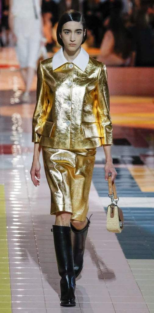 Podczas wrześniowego pokazu wiosennoletniej kolekcji, Miuccia Prada posłała na wybieg modelkę ubraną w efektowny garnitur w kolorze lśniącego, jasnego złota