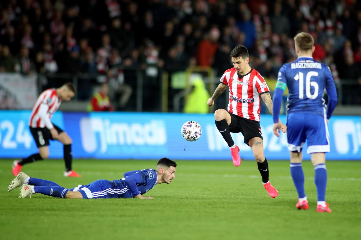 Zawodnik Cracovii Sergiu Hanca (C) oraz Jakub Błaszczykowski (P) i Vukan Savicević (dół) z Wisły Kraków