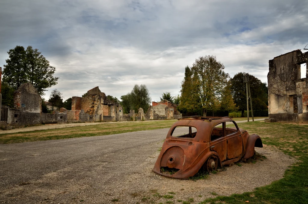 Oradour-sur-Glane Ruiny domów, wraki samochodów na ulicach, zardzewiałe rury na elewacjach. Od ponad siedemdziesięciu lat francuskie miasteczko jest wyludnione. Do masakry w Oradour-sur-Glane we Francji doszło w 1944 roku. Był upalny, czerwcowy dzień, kiedy niemiecki oddział Waffen SS wjechał do miejscowości zamieszkałej przez ponad sześciuset mieszkańców. Oradour-sur-Glane Ruiny domów, wraki samochodów na ulicach, zardzewiałe rury na elewacjach. Od ponad siedemdziesięciu lat francuskie miasteczko jest wyludnione. Do masakry w Oradour-sur-Glane we Francji doszło w 1944 roku. Był upalny, czerwcowy dzień, kiedy niemiecki oddział Waffen SS wjechał do miejscowości zamieszkałej przez ponad sześciuset mieszkańców.