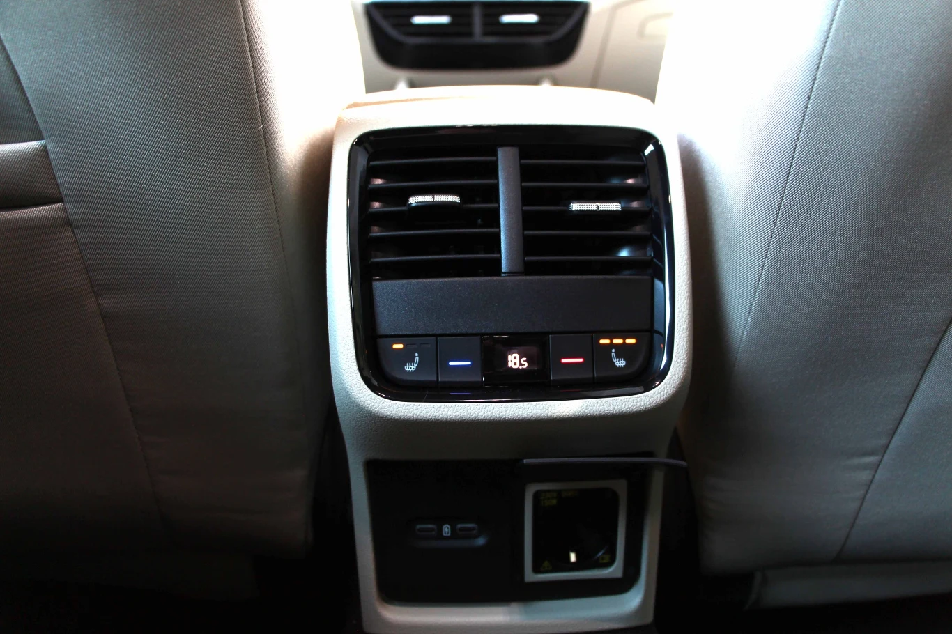 Trzecia strefa klimatyzacji w samochodzie kompaktowym to jest coś. Zewnętrzne miejsca kanapy mogą być ogrzewane. Poniżej dwa łącza USB-C oraz gniazdko 230 V z dużą, okrągłą wtyczką.