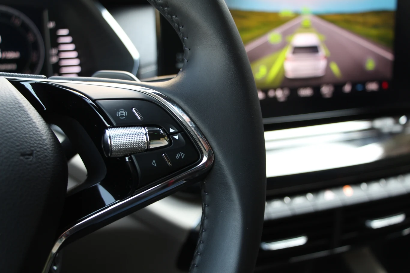 Przycisk wywołujący ustawienia asystentów kierowcy, rolka do obsługi komputera pokładowego i dwa przyciski do przełączania się między widokami wskaźników. Rolka od strony wewnętrznej nie jest przymocowana i wystaje, prawie jakby dało się ją wyciągnąć. Ciekawy smaczek stylistyczny.