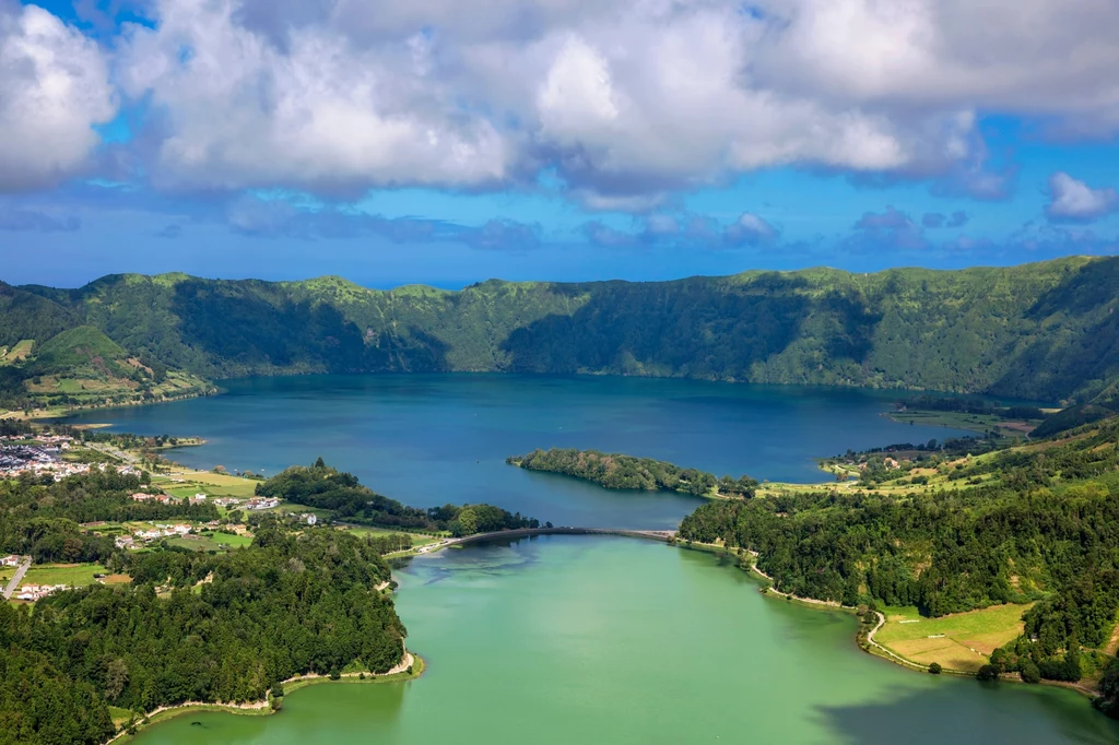 Lagoa das Sete Cidades, wyspa Sao Miguel, Azory, Portugalia Dwa jeziora oddzielone wąskim przesmykiem mają wody o odmiennym zabarwieniu. Jedno z nich jest niebieskie, a drugie zielone. Miejscowa legenda głosi, że to łzy zakochanej nieszczęśliwie pary wypełniają niecki. Zielone wypłakała księżniczka, a niebieskie biedny pasterz. Lagoa das Sete Cidades, wyspa Sao Miguel, Azory, Portugalia Dwa jeziora oddzielone wąskim przesmykiem mają wody o odmiennym zabarwieniu. Jedno z nich jest niebieskie, a drugie zielone. Miejscowa legenda głosi, że to łzy zakochanej nieszczęśliwie pary wypełniają niecki. Zielone wypłakała księżniczka, a niebieskie biedny pasterz.