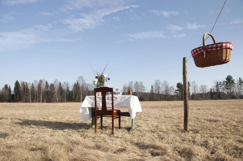 W plenerowej restauracji Bord for En na gości czeka udekorowany stolik, ustawiony pośrodku łąki