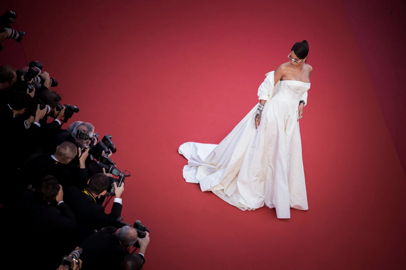 Jeden z najbardziej ikonicznych występów na czerwonym dywanie w historii canneńskiego festiwalu zaprezentowała w 2017 roku Rihanna, która na uroczystej premierze filmu "Okja" pojawiła się w imponującej kreacji pochodzącej z kolekcji Dior Haute Couture. Powłóczystą, niemalże balową suknię z białej jedwabnej tafty gwiazda zestawiła z lekkim płaszczem z tej samej tkaniny, który nonszalancko narzuciła na ramiona, eksponując dekolt.

Piękna Barbadoska zadbała w swojej stylizacji o najdrobniejsze szczegóły. Prócz sukni autorstwa jednego z najsłynniejszych na świecie domów mody uwagę przykuwały bowiem również dodatki - bogata diamentowa biżuteria oraz okulary, które wieczorowej kreacji dodały świeżości i charakteru.