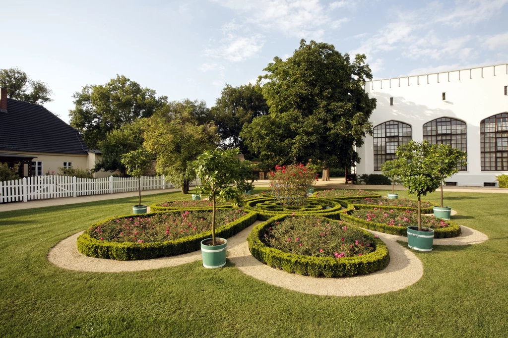 Park Mużakowski Żyjący w XVIII i XIX wieku książę Hermann Ludwig Heinrich von Pückler-Muskau, podczas licznych podróży do Anglii zachwycił się tamtejszymi ogrodami. Zainspirowany malowniczymi, krajobrazowymi założeniami, postanowił na ich wzór zaaranżować część własnej posiadłości. Okazja nadarzyła się, gdy w 1811 odziedziczył po ojcu posiadłość w Muskau, na którą składał się zamek i spory zielony teren. Trzeba przyznać, że arystokrata do realizacji swojej koncepcji podszedł z rozmachem: zlecił przemodelowanie terenu, wybudowanie mostów przez Nysę, nasadzenie tysięcy drzew i krzewów. Niestety, ambitna inwestycja mocno wydrenowała książęcą kieszeń: arystokrata musiał sprzedać majątek i opuścić posiadłość. Krajobrazowa koncepcja nie została jednak porzucona, a jej realizację kontynuowali kolejni właściciele. Dziś założenie obejmuje powierzchnię ponad 700 ha, leżących zarówno po polskiej, jak i po niemieckiej stronie Nysy. 