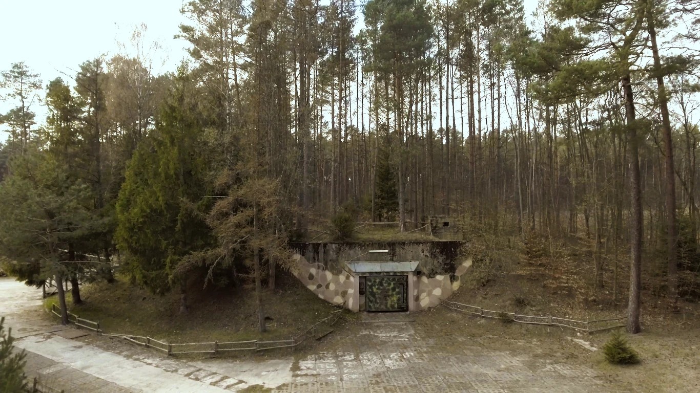 Mało kto wie, że w Polsce odnaleźć możemy – i to niemal w kompletnym stanie - opuszczoną sowiecką bazę, która służyła ukrywaniu i składowaniu broni atomowej! Ukryta w gęstwinie podborskich lasów pozostawała tajemnicą przez wiele lat. Od powstania w końcówce lat 60. XX wieku, nosiła kryptonim „Obiekt 3001”, a jej ponad 300 ha obszar był wyłączony z terytorium Polski i ochraniany przez siły specjalne Specnaz. Do dziś nie wiemy, ile głowic nuklearnych tam przechowywano, choć przygotowano specjalne magazyny na 160 bomb. W razie wybuchu wojny jądrowej, pociski miały być przetransportowane do nieodległego lotniska wojskowego w Bagiczu. Pod koniec Zimnej Wojny w bazie wybudowano także silos dla rakiet z głowicami nuklearnymi, więc skład amunicji mógł zostać przekształcony w stanowisko bojowe. Po wycofaniu wojsk radzieckich bazę przejęła polska Marynarka Wojenna, a potem stworzono tu oddział Zakładu Karnego w Koszalinie. Dziś Podborsko to Muzeum Zimnej Wojny. Mało kto wie, że w Polsce odnaleźć możemy – i to niemal w kompletnym stanie - opuszczoną sowiecką bazę, która służyła ukrywaniu i składowaniu broni atomowej! Ukryta w gęstwinie podborskich lasów pozostawała tajemnicą przez wiele lat. Od powstania w końcówce lat 60. XX wieku, nosiła kryptonim „Obiekt 3001”, a jej ponad 300 ha obszar był wyłączony z terytorium Polski i ochraniany przez siły specjalne Specnaz. Do dziś nie wiemy, ile głowic nuklearnych tam przechowywano, choć przygotowano specjalne magazyny na 160 bomb. W razie wybuchu wojny jądrowej, pociski miały być przetransportowane do nieodległego lotniska wojskowego w Bagiczu. Pod koniec Zimnej Wojny w bazie wybudowano także silos dla rakiet z głowicami nuklearnymi, więc skład amunicji mógł zostać przekształcony w stanowisko bojowe. Po wycofaniu wojsk radzieckich bazę przejęła polska Marynarka Wojenna, a potem stworzono tu oddział Zakładu Karnego w Koszalinie. Dziś Podborsko to Muzeum Zimnej Wojny.