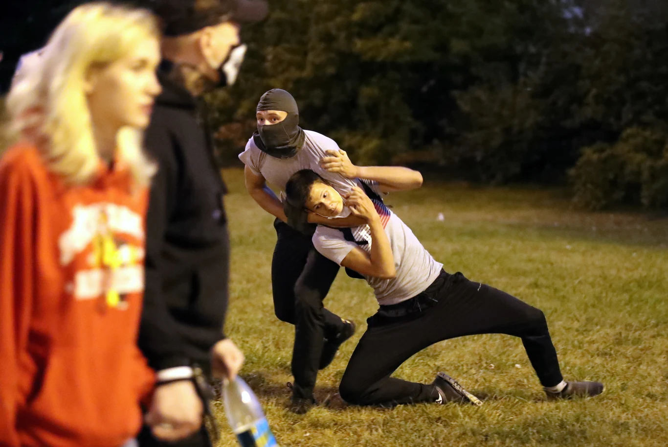 Jeden z protestantów obezwładniony przez zamaskowanego członka służb specjalnych.