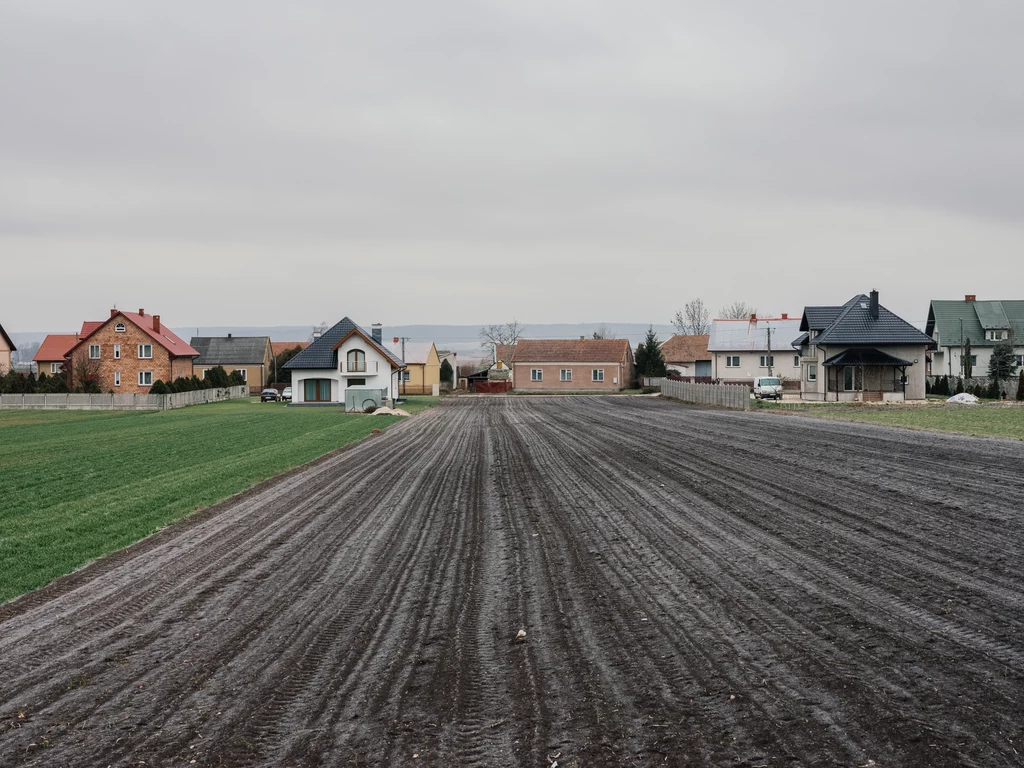 Wiejski krajobraz to mieszanka tradycyjnej zabudowy, nowo powstałych domów i przemysłowej infrastruktrury