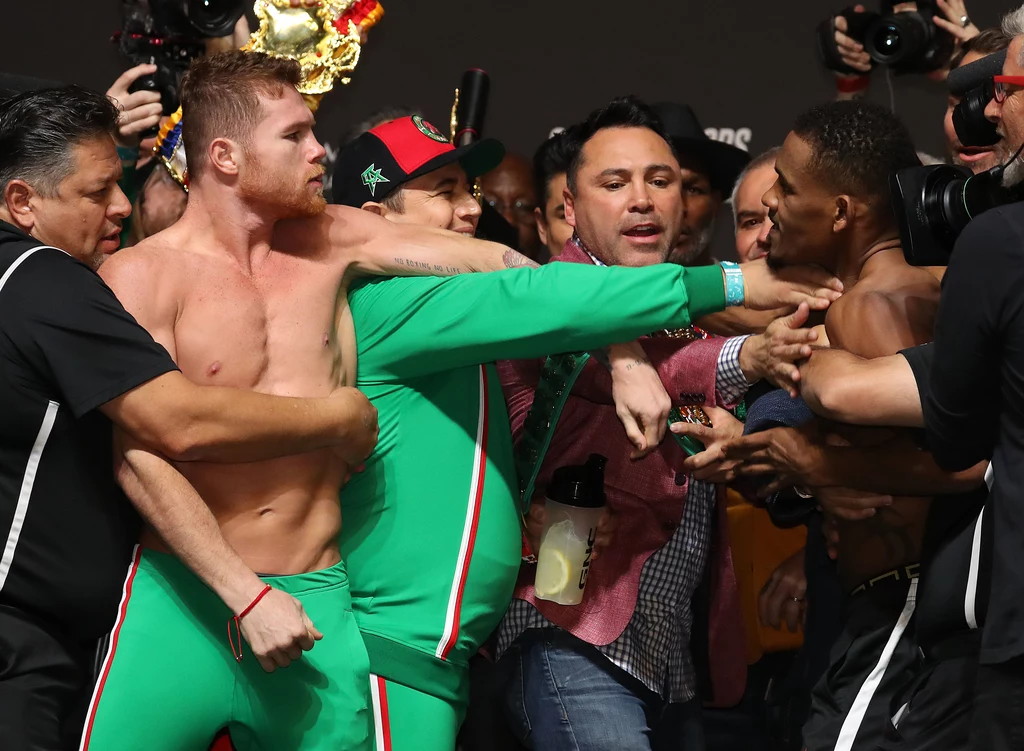 Saul Alvarez jest powstrzymywany, ale nitk nie powstrzymał go, by pozwać Oscara de la Hoyę (w środku)