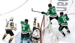 Anton Chudobin #35 z Dallas Stars nakrywa krążek, Brayden McNabb #3 z Vegas Golden Knights upada na niego