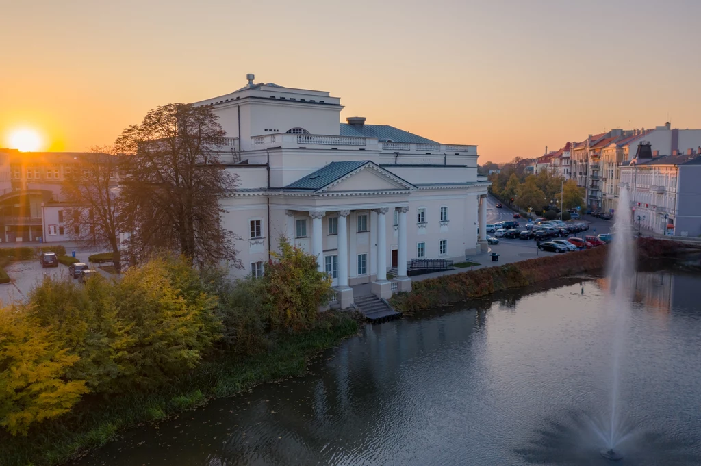 Gmach „teatru na wodzie” w Kaliszu, zbudowany w dwudziestoleciu międzywojennym, architektonicznie dopasowany został do ratusza. Tekst: DJ Źródło: Życie na gorąco Gmach „teatru na wodzie” w Kaliszu, zbudowany w dwudziestoleciu międzywojennym, architektonicznie dopasowany został do ratusza. Tekst: DJ Źródło: Życie na gorąco