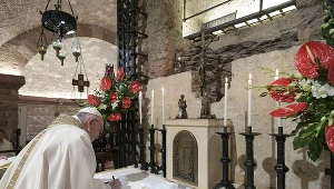 Papież Franciszek podpisujący w Asyżu nową encyklikę