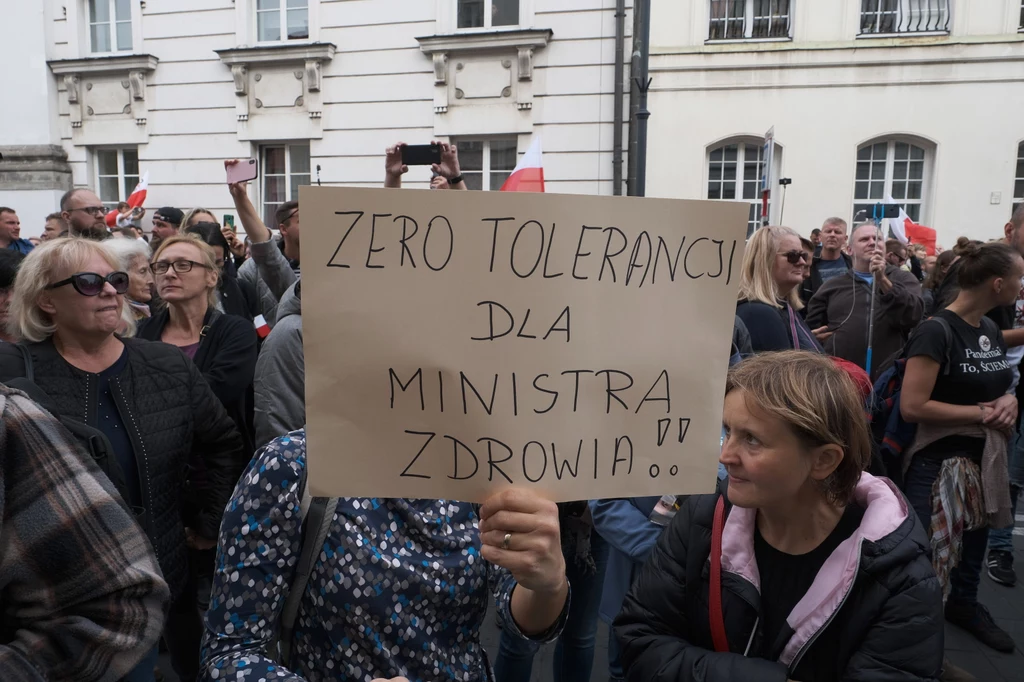 W pobliżu manifestujących przeciwników obostrzeń przejeżdżał policyjny samochód. Z głośników emitowano informacje o obowiązującym od soboty w całym kraju nakazie zakrywania ust i nosa.