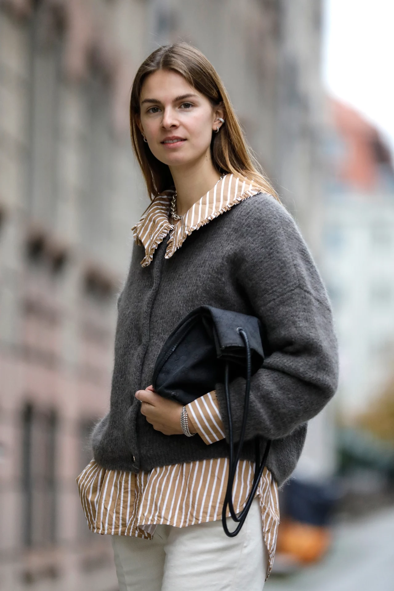 Jacqueline Zelwis ma na sobie koszulę w paski od Samsoe Samsoe, kremowe spodnie od Sezane, szary kardigan od Gestuz i torebkę Gucci.